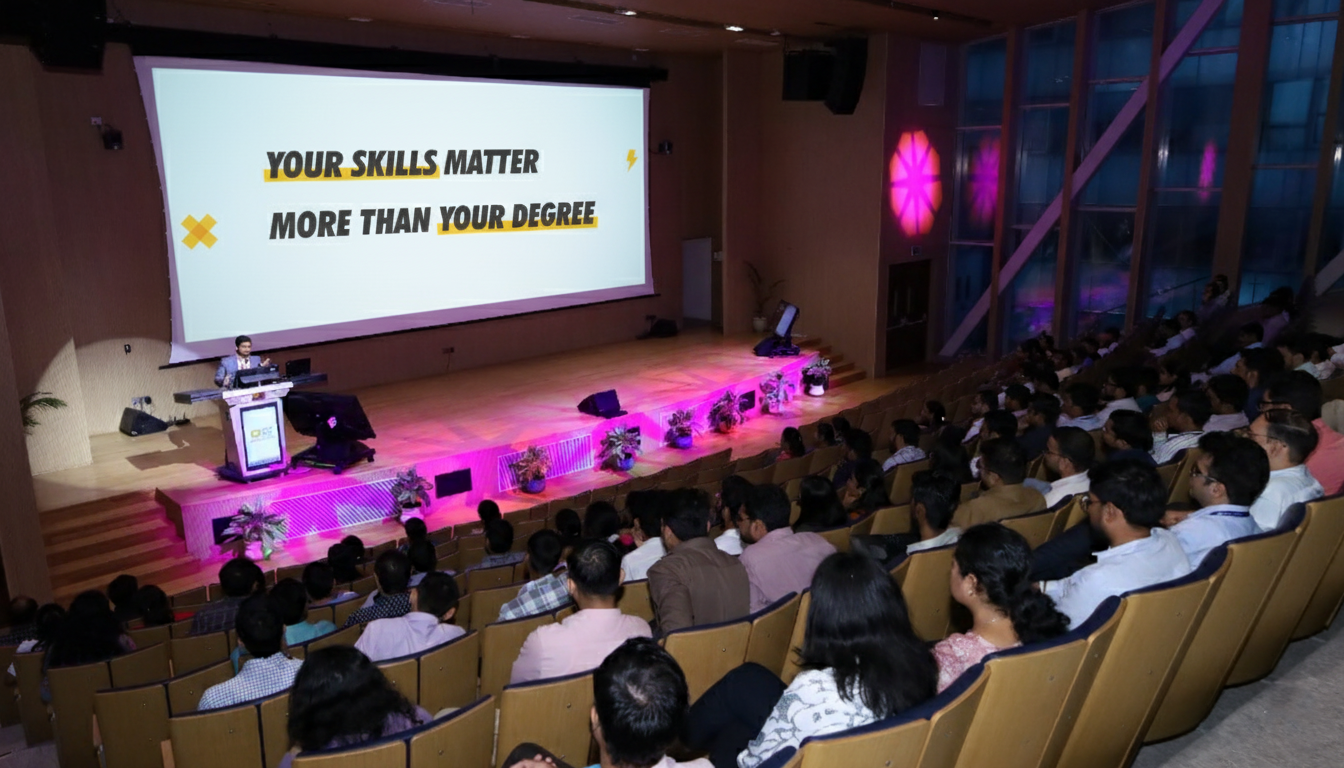 Audience in a lecture hall with Aman Jaiswal on stage and a motivational slide projected on screen.